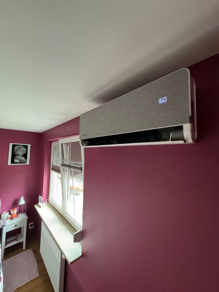 Montaż Versu Cloth Stone z materiałowym szarym frontem umiejscowiony obok okna w sypialni